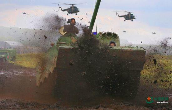 资料图片：“和平使命-2018”参演中方坦克在空中火力掩护下向预定地域开进。（中国军网）