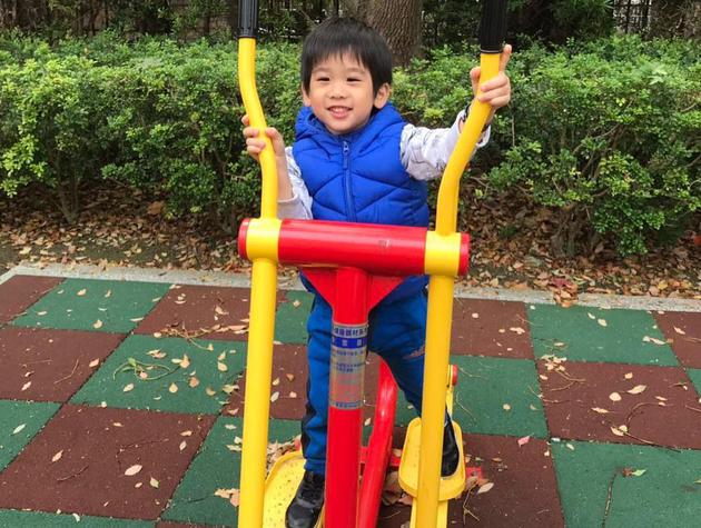 Jenson认真地踩在器材上做锻炼，并且开心地看着镜头