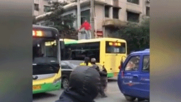 实拍:嚣张女子当街爬公交车顶 脱鞋狂砸民警