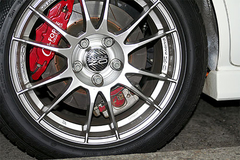 为什么汽车前轮卡钳在刹车盘后而后轮在前？