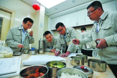 在集控中心小餐厅,田中越(右二)和同事们边就餐边讨论工作。