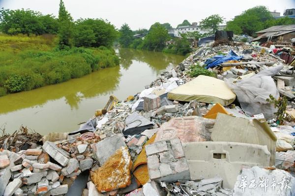 江安河河道被建筑垃圾侵占。