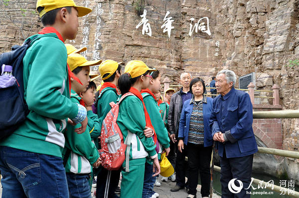 当年修筑红旗渠的劳模在向小学生讲解