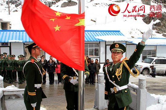 5月2日,中印乃堆拉边贸通道迎来今年开关,图为亚东边检站官兵在国门前升起国旗。