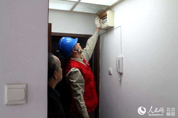 丽利一边和郑丽红聊着家常，另一边党员服务队的另外一名工作人员就开始了电路检查工作。人民网 赵青摄