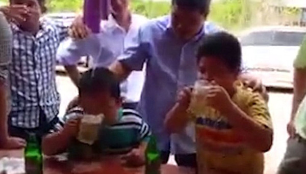 一群成年人让幼童参加喝啤酒竞赛，并且可能押了注。（网页截图）
