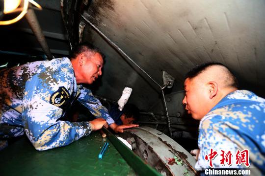 深入主机舱，和官兵一道检修装备。　代宗锋 摄