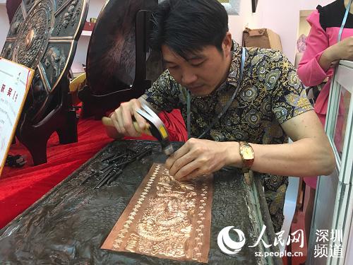 倪荣珍现场表演铜雕。（袁俪芸 摄）