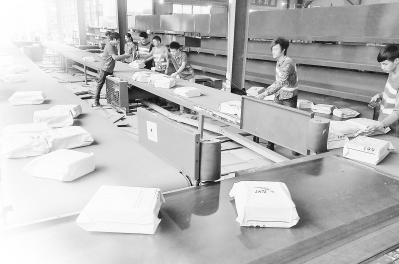 在晋江磁灶镇的福建中通分拨中心里,快递员正在将全国各地发来的快件进行分拨。