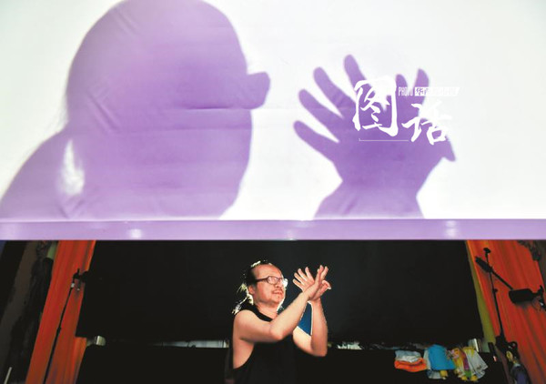 沈晓在幕布后、灯光前变换双手，时而刚劲有力，时而婀娜妖娆。