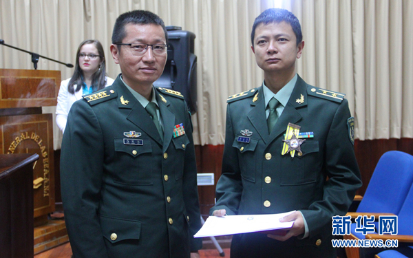 5月20日，中国驻厄瓜多尔使馆武官高怀玉（前左）为军医谢志浩授勋。新华网记者梁君茜摄