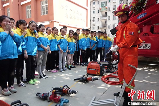 5月10日，消防员在为学生们演示消防救援工具。 中新社记者 张娅子 摄