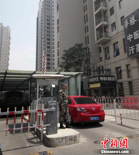 5月30日中午，在北京市朝阳区某小区，一名保安穿着迷彩制服站岗。吕春荣摄