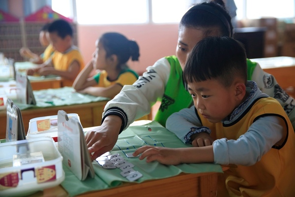 5月31日,河南省平顶山市宝丰县一家幼儿园的小朋友在老师的指导下玩智力卡片。