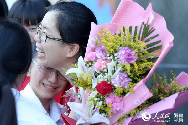 一名高三毕业生将鲜花送到老师手上时，抑制不住情绪抱着老师哭了起来