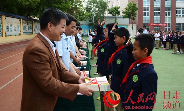 甘肃省高级人民法院少年法庭与兰州市两级法院少年法庭的法官们为学生们赠送了《青少年法制教育读本》。（王文嘉 摄）