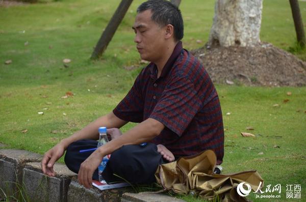 南昌二中的考点外，家长们在阴凉处等待首场考试结束。