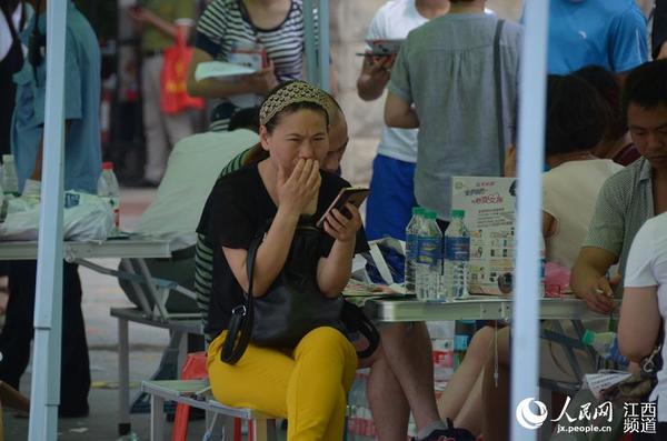 南昌二中的考点外，家长们在阴凉处等待首场考试结束。