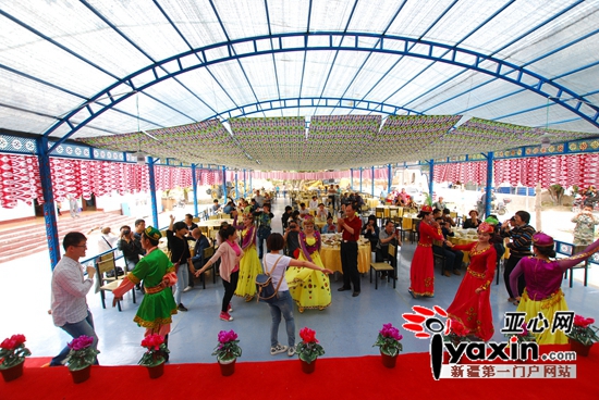 游客在工作组极力打造的歌舞餐饮广场同演员共跳麦西来甫。