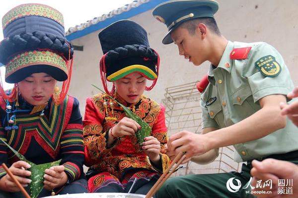 6月8日,武警四川省总队凉山州支队七中队官兵和彝族老乡一同包粽子迎端午节。(李结义 摄)