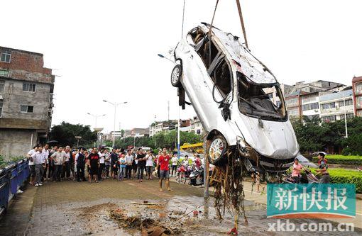 ■吊车在清理被洪水冲入河道的汽车。