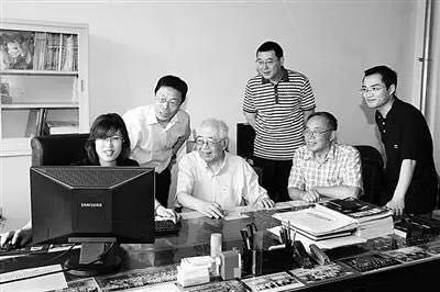 张存浩（左三）与同事探讨实验文体。 图片来源：经济日报