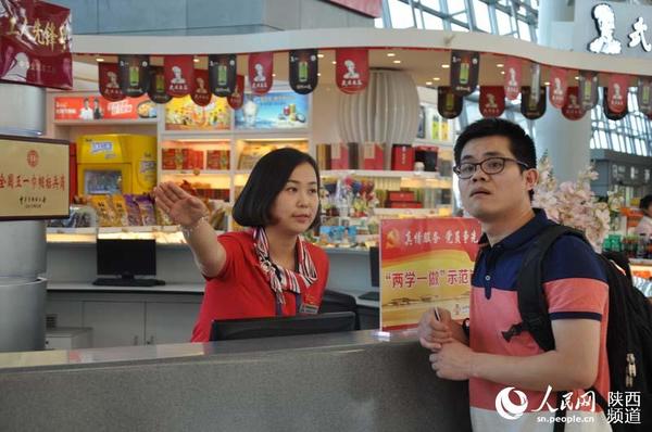 西安咸阳国际机场航站楼内“两学一做”示范岗工作人员热心服务旅客，耐心答疑解惑。张伟 摄