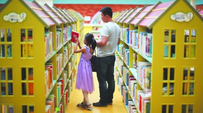 18日，一位父亲带着孩子在辽宁省图书馆借阅图书。