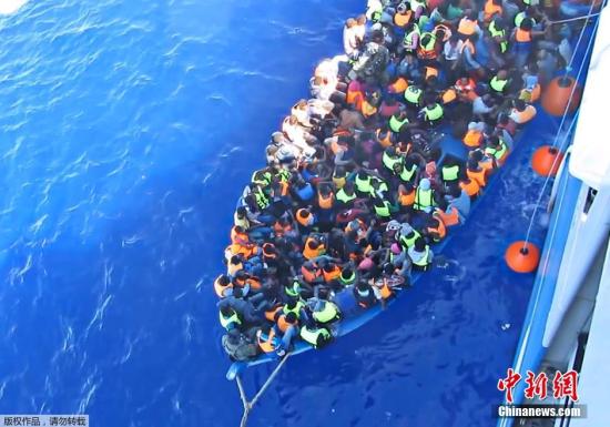 资料图：在地中海被解救的难民登上小筏。