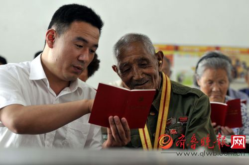 6月27日,临沂市郯城县马头镇党委工作人员宋伟和不识字的抗战老兵兰兆法(中)一起学习党章
