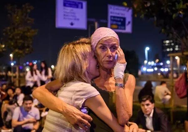 　　两名旅客在爆炸发生后拥抱（6月28日摄）。新华社/法新