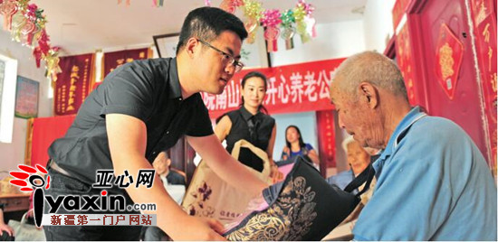 当日，新疆锦嘉苑房地产开发有限公司小院南山经理李勋将慰问品送到老人手中。亚心网记者豆兴军摄