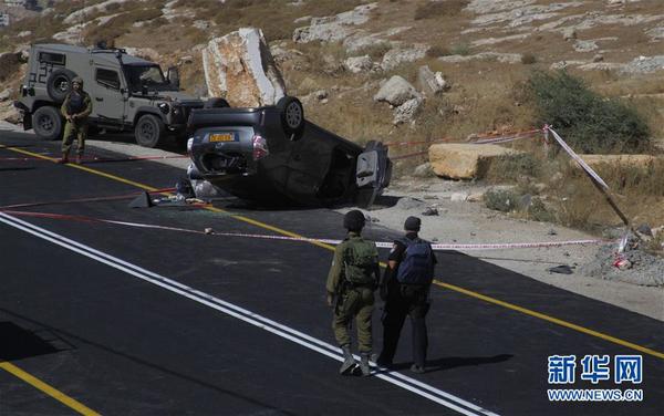 　　7月1日，在约旦河西岸南部城市希伯伦附近，以色列安全人员查看袭击现场。