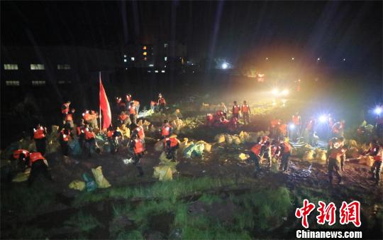武警湖北省总队黄冈支队官兵正在连夜抢筑堤坝　郭峰　摄