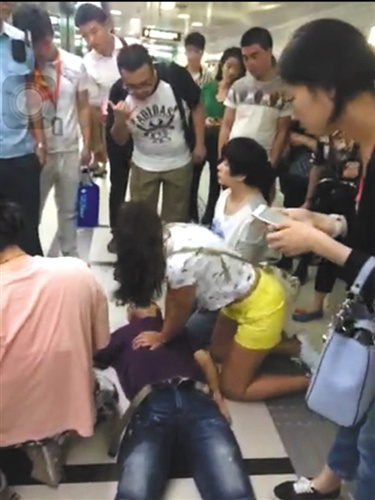 一位外籍女士志愿对倒地的金波进行心肺复苏。(视频截图)图片来源：新京报