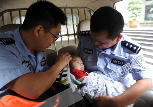 民警将被遗弃的男婴接回派出所。渝中警方供图
