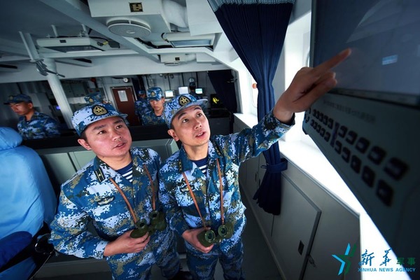 范文武（右）在宿州舰与舰长范小敢一起研究训练方案。（2016年7月1日摄）新华社记者查春明摄