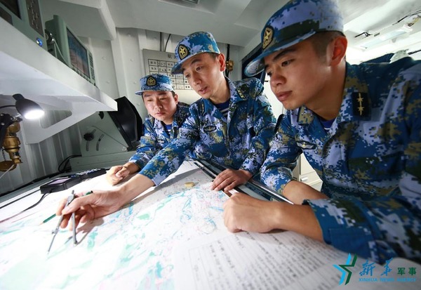 范文武（中）在宿州舰海图室与舰上官兵一起研究方案。（2016年7月1日）新华社记者查春明摄