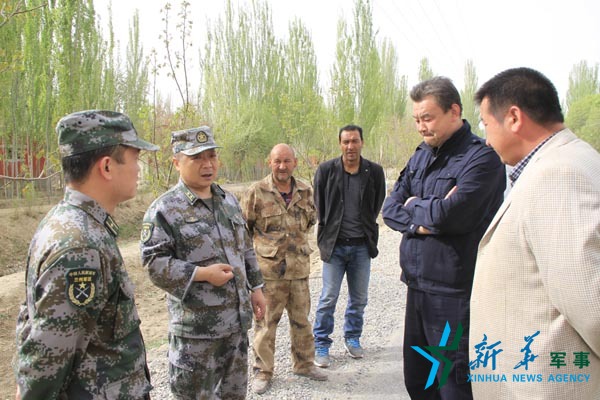 资料照片:侍振江与地方人员商议为村修公路问题
