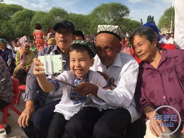 　　买买提在活动现场和村民一起自拍