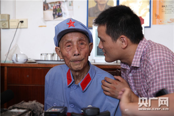 今年97岁钟发镇有点耳背，采访过程其孙子时不时在旁边提醒 央广网记者王晶摄