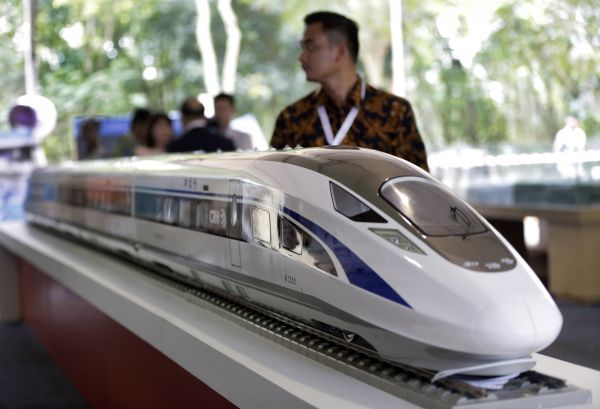 1月21日，在印度尼西亚西爪哇省瓦利尼，一名参观者在开工仪式上走过高铁列车模型。（新华/美联）