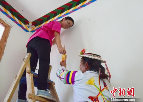 图为桂翠荣和志愿者一起修建家庭旅舍。　闫明 摄