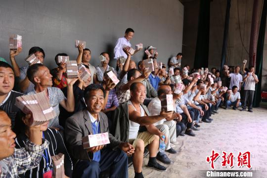 圖為領到分紅村民一起合影。 劉玉桃攝