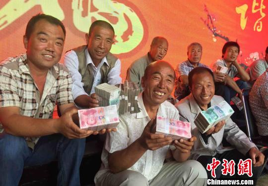 圖為領到分紅的村民開心坐在一起聊天。 劉玉桃攝