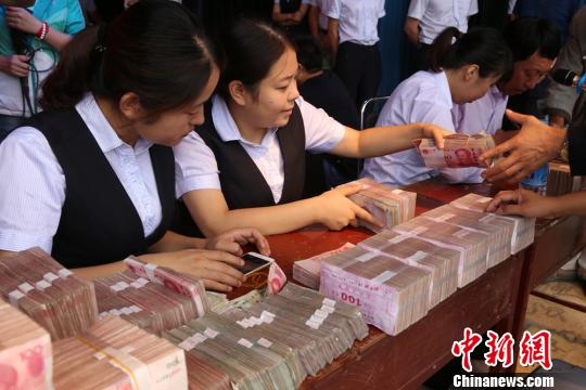 圖為銀行工作人員點鈔。 劉玉桃攝