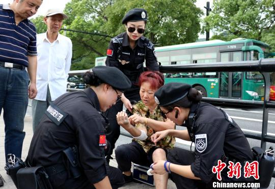 图为杭州西湖女子巡逻队队员帮助游客处理伤口。　何蒋勇 摄