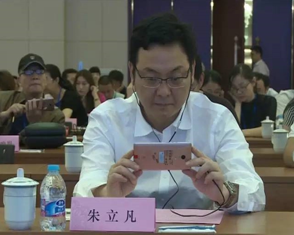 张家港市委书记朱立凡在用手机观看裸眼3D城市宣传片。