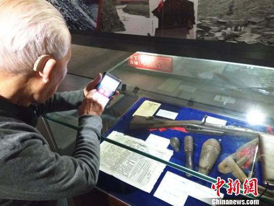 88岁高龄的邱月杭老人正在用手机拍照片。　王哲 摄