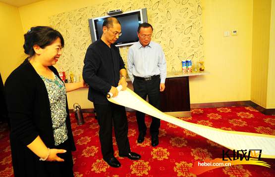 蔚县县领导观看冯骥才先生的题词和《中国的雪绒花在哪里》楷体书法。